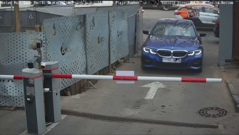 Production ANPR camera at a vehicle access gate: a sedan approaching the barrier, with the vehicle and its license plate detected.
